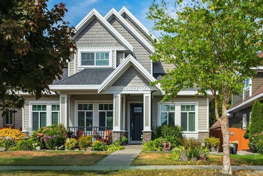 Gray craftsman home with covered porch and landscaped front yard