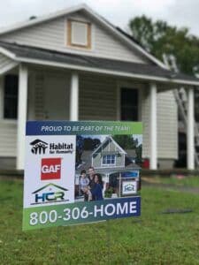 a real estate sign in front of a house.