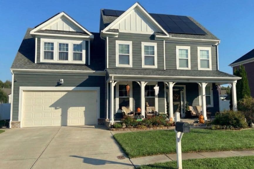 Modern two-story gray home with solar panels and front porch