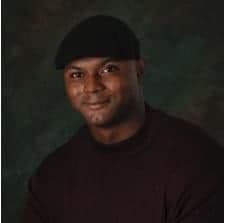 a man in a black shirt and a black hat.
