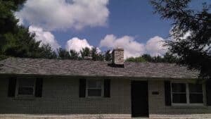 a brick house with a black door and windows.